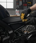 Pro Grade Aluminum Alloy Motorcycle Chain Adjuster With Slick Roller Wheel adjuster installed on bike for maintenance in garage.