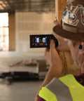 Construction worker using Beast Of A Blaze Outdoor Connected Laser Measure With 400 Ft Range, 5 MP Digital Viewfinder on building site