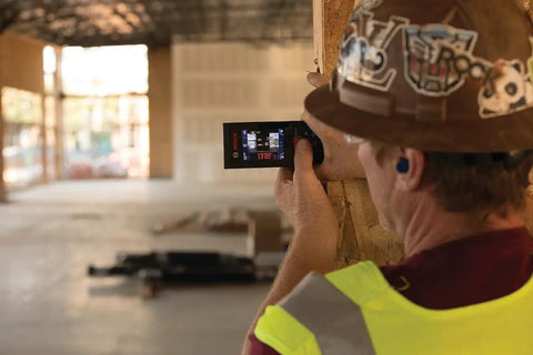Construction worker using Beast Of A Blaze Outdoor Connected Laser Measure With 400 Ft Range, 5 MP Digital Viewfinder on building site