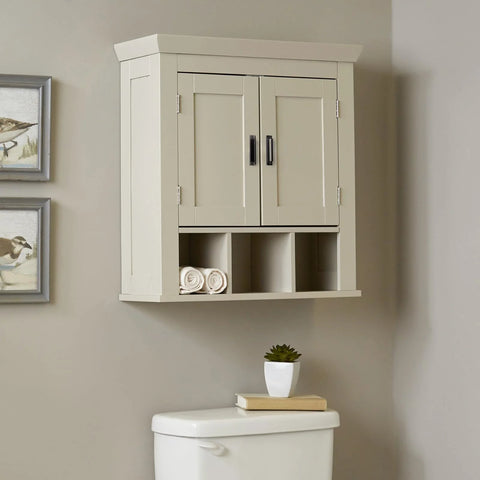 Cream bathroom wall cabinet with two doors and black handles, displayed above a toilet, featuring decorative wall art on the side.