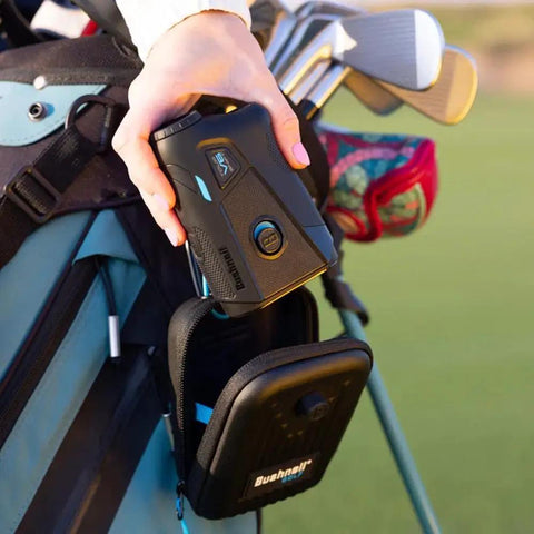 Hand holding V6 Shift Laser Rangefinder With Slope Compensation And PinSeeker, attached to golf bag with carry case visible.