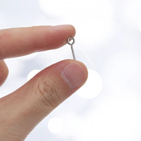 100 Pack Stainless Steel Eye Hooks 0.66 Inch Silver Heavy Duty Eye Screws held between fingers for DIY projects