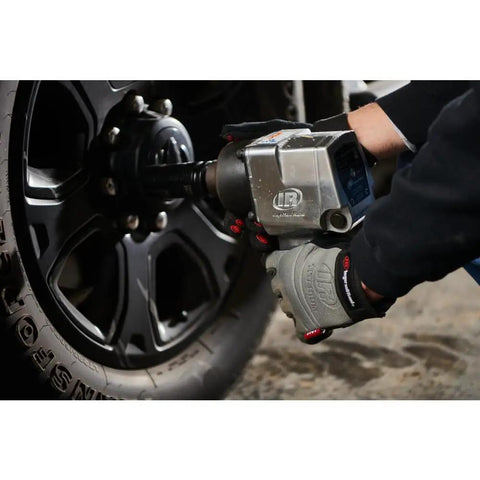 Badass 3/4 Inch Drive Air Impact Wrench Delivering Straight Up 1100 Ft Lbs Max Torque in use on a black wheel, featuring a pistol grip handle.