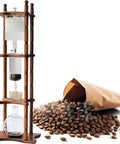 Real Deal Cold Brew Coffee Maker And Iced Drip Tower With Adjustable Stainless Steel Flow Control For Ultra Smooth Low Acid Iced Coffee In A Roomy 3000Ml Glass Carafe with coffee beans and wooden structure.