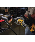 DEWALT DCG426B 20V Max die grinder with battery, yellow body, used on metal pipe with sparks.