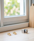 4-Pack Brass Pneumatic Tee Fittings With Female Threaded 3-Way Design displayed on wooden table near window