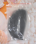 Black Golf Ball Storage Bag Portable Drawstring Pouch in packaging, polyester nylon mesh material behind seashell background