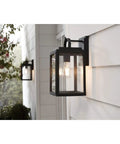 Grandbury Collection 1-Light Clear Glass Farmhouse Outdoor Wall Lantern in Textured Black mounted on a porch