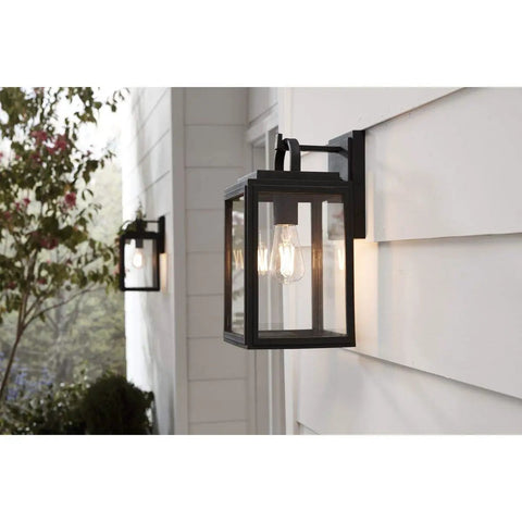Grandbury Collection 1-Light Clear Glass Farmhouse Outdoor Wall Lantern in Textured Black mounted on a porch