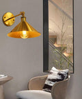 Built Tough Industrial Metal Swing Arm Wall Sconce Adjustable E27 Light Fixture Reinforced Mount with gold finish in stylish living room setting.