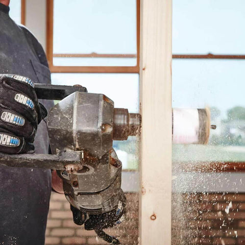 Lenox 2-3/4in bi-metal speed-slot hole saw, side view, mounted on a drill cutting wood.