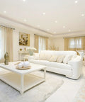 Living room with 4 Pack 5 to 6 Inch LED Recessed Can Lights, modern white decor, white sofa, high ceiling, ample daylight.