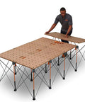 Man assembling Centipede Workbench Tabletop For On The Go Portable Centipede Stand Saw Horses 24 Inch By 48 Inch Wood Top With Dog Holes