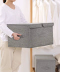 Collapsible Linen Fabric Storage Bin For Clothes Shoes And Toys Nifty Foldable Home Basket being held by a person in white shirt.