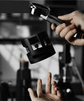 Game Changing 58mm Espresso Portafilter Station held above a hand, showing metal construction for stable tamping.
