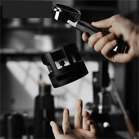 Game Changing 58mm Espresso Portafilter Station held above a hand, showing metal construction for stable tamping.