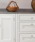 Hella Durable 2 Pack Polished Nickel Cabinet Knobs With Backplates on white cabinet with eggs in basket, highlighting 2.8-inch design.