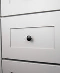Round Matte Black Kitchen Cabinet Knobs 10 Pack Durable Drawer And Dresser Knobs For Cabinets And Bathroom Drawers One And One Eighth Inch Easy Install Slick Modern Hardware By Hickory Hardware installed on a white cabinet drawer