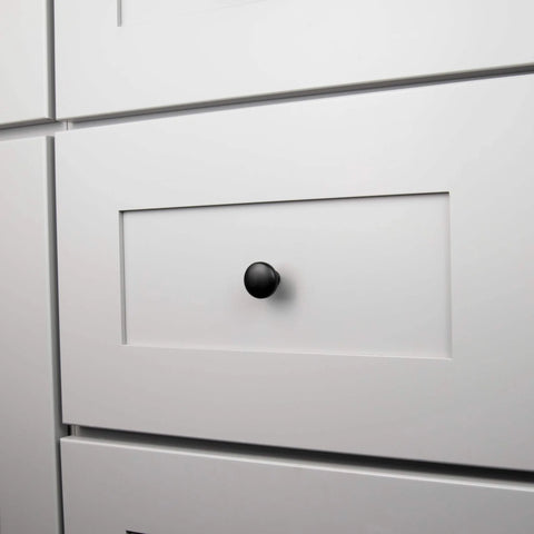 Round Matte Black Kitchen Cabinet Knobs 10 Pack Durable Drawer And Dresser Knobs For Cabinets And Bathroom Drawers One And One Eighth Inch Easy Install Slick Modern Hardware By Hickory Hardware installed on a white cabinet drawer