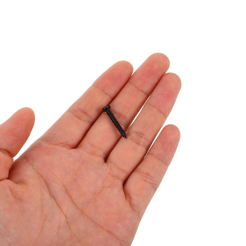 Hand holding a screw from the 450 Piece Black Carbon Steel Self Tapping Screws Kit With Round Phillips Heads