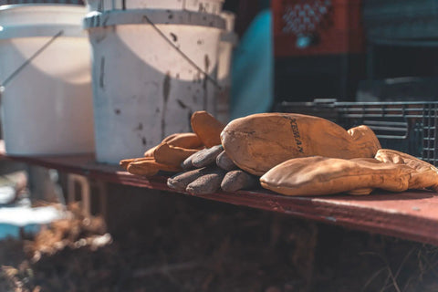 Heavy Duty Full Grain Cowhide Cold Weather Mittens Built Dang Tough With Heat Keep Thermal Insulation piled on a workbench.