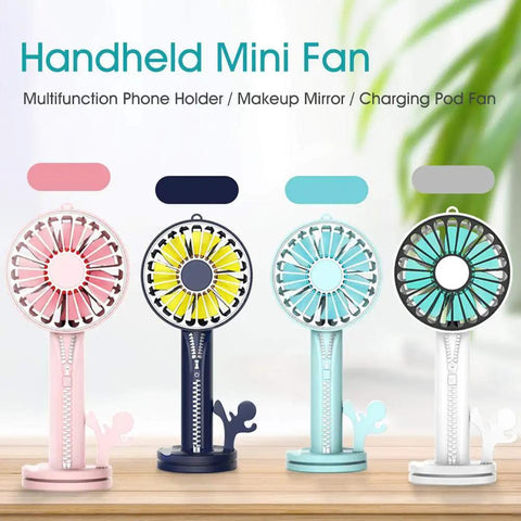 Four handheld mini fans in pink, navy, teal, and gray with multifunctional features on a wooden surface.