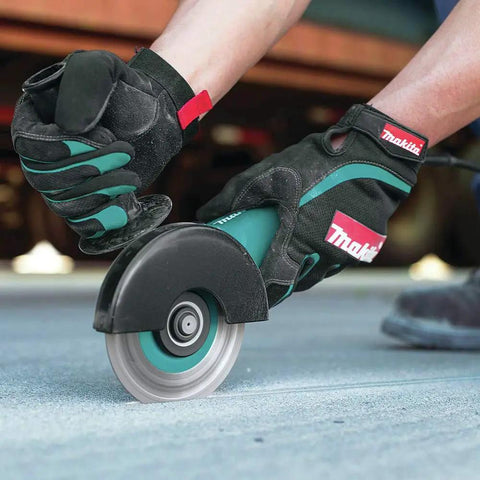 Hands using Four And A Half Inch Angle Grinder With Seven Point Five Amp Motor Delivers Eleven Thousand RPM AC DC Switch on concrete