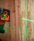 Compact Self Leveling Laser Level With Plumb Spot, Bright Green Cross Lines, 75 Foot Range, Class 2 Laser attached to wood surface