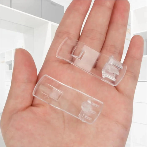 Clear Plastic Shelf Clips 40 Or 50 Piece Set Self Locking Cabinet Support Pegs for One Quarter Inch Holes resting on a hand