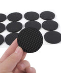 12 Pack Black Rubber Floor Pads With Adhesive Round Furniture Protectors for Chairs, Tables, Sofas, and Wooden Floors shown in hand