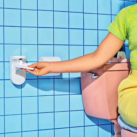 Person using wall-mounted Touchless Toilet Paper Foam Dispenser Kit Turns Regular Toilet Paper Into Flushable Wipes