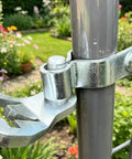 Close-up of Heavy Duty T Post Gate Hinge Assembly Kit With Galvanized Steel Pins attached to a metal post for fence installation.