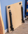 Folded Knock Down Outfeed Table Kit With Foldable Legs For Small Shops, Removable Extension For Table Saws, leaning against wall