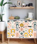 Dead Simple Peel And Stick Wallpaper Pink Safari Jungle Zoo Design Self Adhesive Vinyl Roll on a white dresser with animal prints.