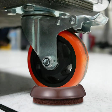 Close-up of a caster on a felt chair leg pad and caster cup set, protecting a hardwood floor from scratches.