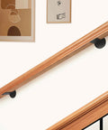 Rock Solid 2 Ft Premium Wood Stair Handrail For Indoor Outdoor Walls with black brackets on wall in modern home setting.