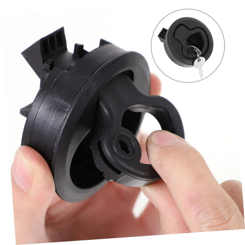 Close-up of black round flush-pull boat latch with locking mechanism, held in hand.