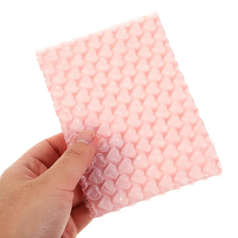 Hand holding Pink Heart Shaped Bubble Mailers Pack For Jewelry And Delicate Items With Shockproof Plastic Bags