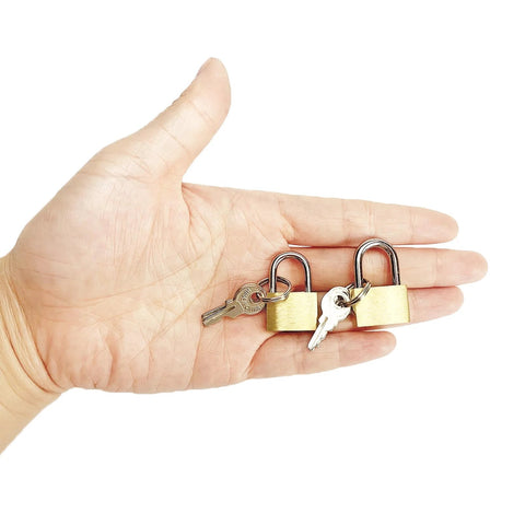 Hand holding two pack small solid brass padlocks with keys 20mm and 25mm mini key locks for luggage backpacks gym lockers jewelry boxes