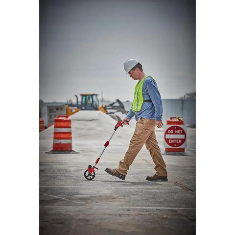 Man using Heavy Duty 6 Inch Measuring Wheel For Construction Sites Built Tough With Reinforced Pivot Top Brake Ergonomic Grip.