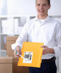 Person holding Kraft Bubble Mailers 8.5x11 Inch Self Sealing Padded Envelopes Yellow Pack Of 50, showing self adhesive seal