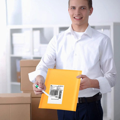 Person holding Kraft Bubble Mailers 8.5x11 Inch Self Sealing Padded Envelopes Yellow Pack Of 50, showing self adhesive seal