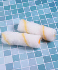 Two mini paint roller sleeves with yellow stripes on a tiled surface, part of Thirty Piece Mini Paint Roller Sleeves With High Density Foam To Banish Ugly Track Lines And Deliver A Smooth As Silk Wall Finish While Providing Quick Dry Coverage That Always Hits The Spot Without Breaking The Bank.