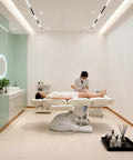Qnoxlim Full Electric Massage Table With Lift, Whole Piece 3 Motor Professional Facial Bed in spa setting with client receiving treatment.
