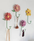 Rock Solid Steel Wall Mount Coat Rack Multipurpose Entryway Hanger for Coats Bags Keys and Towels on a wall with floral designs.