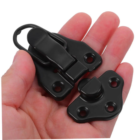 Hand holding part of Eight Piece Retro Duckbilled Hasp Lock Set For Luggage And Antique Boxes Spring Lock Metal Clasp With Quick Release Buckle Rugged Hardware Built To Last.