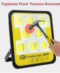 Gritproof Rechargeable Led Work Light With Solar Panel And Remote Control 200 Watt Waterproof Flood Lamp being struck with a hammer.