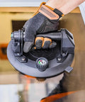 Hand using 8 Inch Electric Vacuum Suction Cup Heavy Duty Lifter For Glass Wood Drywall Granite Tile Sucker With One Button Start And Automatic Pump To Move Large Panels Up To 440 Lbs No Sweat on glass panel