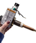 Hand holding Gas Water Heater Control Thermostat NG Natural Gas For PROG40-40N RH62 And PROG50-40N RH62 next to warning label