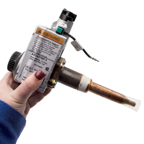 Hand holding Gas Water Heater Control Thermostat NG Natural Gas For PROG40-40N RH62 And PROG50-40N RH62 next to warning label
